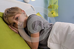 Ill child lying in hospital bed