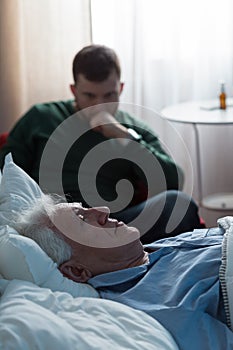 Ill father lying in hospital bed