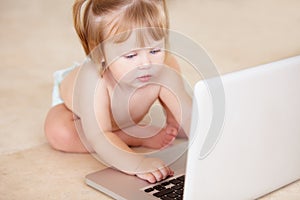 Ill figure this out. A cute little girl playing with a laptop.