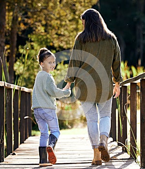 Ill always hold your hand. a young mother and daughter spending time at a park.