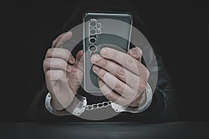 Ill-intended fraudster uses mobile. Fraudster calls. . Hacker hijacks by phone. Cellphone account fraud. Scam. handcuffs