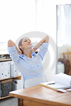 Ill just close my eyes for a second...young businesswoman taking a moment to relax at her desk.