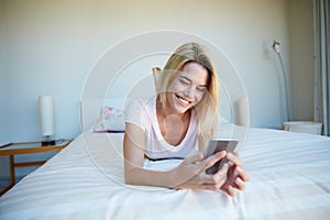 Ill just let my fingers do the socialising. a young woman using her cellphone while relaxing in her bedroom.