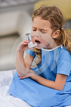 ill kid using asthma inhaler