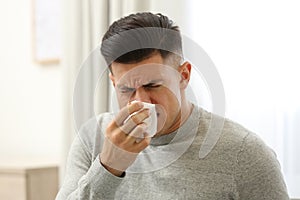 Ill man with paper tissue at home