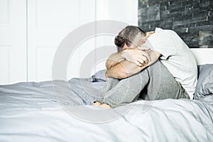 Ill man sitting on his bed