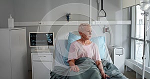 Ill mature woman with nasal cannula sitting in hospital bed