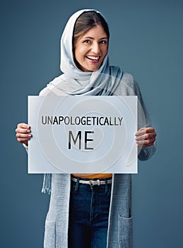 Ill never apologize for being myself. Studio portrait of an attractive young woman holding up a sign reading