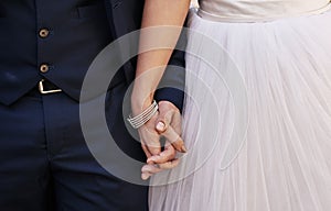 Ill never let go. an unrecognizable newlywed couple holding hands while standing outdoors on their wedding day.