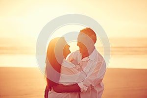 Ill never let you go. an affectionate mature couple embracing on the beach at sunset.