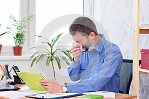 Ill office worker sneezes at work place