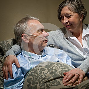 Ill old man lying bed with wife