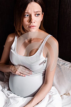 Ill pregnant woman measuring temperature with