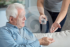 Ill senior man taking medicine photo