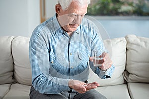Ill senior man taking pill photo