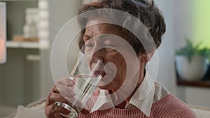 Ill sick thirst Caucasian old woman refreshing with glass of still water senior female mature granny retired grandmother