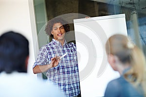 Ill take all questions later....Casual young businessman giving a presentation using a whiteboard.