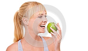 Ill always take the healthy option. An attractive young woman eating an apple isolated on white.