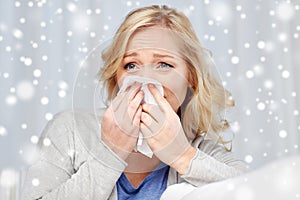 Ill woman blowing nose to paper napkin