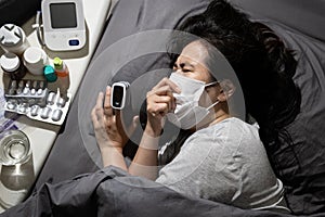 Ill woman patient with fever cough lying in bed at her home,Coronavirus crisis,hospital bed is full during COVID-19 pandemic,self-