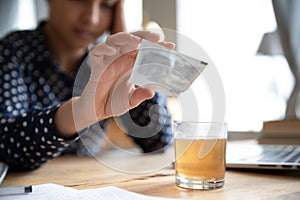 Ill woman pour medicine powder into glass relieve flu symptom