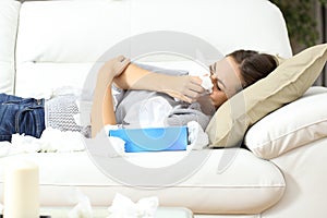 Ill woman sneezing in tissue flu concept
