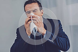 Ill young man holding a paper tissue