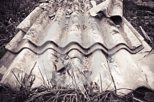Illegal asbestos dumping - Roofing asbestos panels illegally abandoned in nature - toned image photo