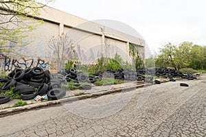 Illegal Dumping of Old Tires and Other Junk Next to an Abandoned Building