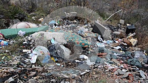 Illegal dumping. Wild garbage dump in nature. Open landfill site. Pile of garbage. Environmental pollution. Waste on landfill area