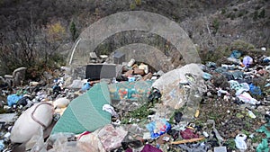 Illegal dumping. Wild garbage dump in nature. Open landfill site. Pile of garbage. Environmental pollution. Waste on landfill area