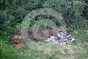 Illegal garbage dump among the trees in the forest. Garbage unlawfully