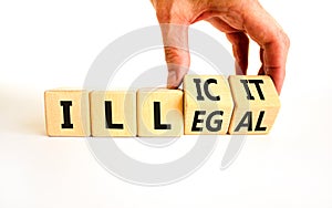 Illegal or illicit symbol. Businessman turns wooden cubes and changes the concept word Illegal to Illicit. Beautiful white table
