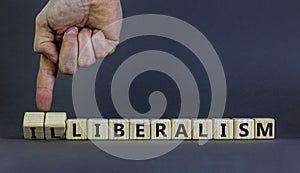 Illiberalism or liberalism symbol. Businessman turns cubes and changes the word `illiberalism` to `liberalism`. Beautiful grey