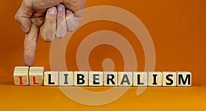 Illiberalism or liberalism symbol. Businessman turns cubes and changes the word `illiberalism` to `liberalism`. Beautiful oran