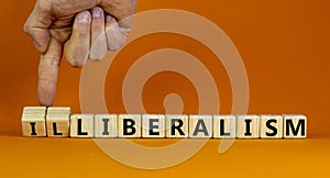 Illiberalism or liberalism symbol. Businessman turns cubes and changes the word `illiberalism` to `liberalism`. Beautiful oran