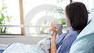 Illness asian patient women on bed seeing windows in room alone of hospital and copyspace