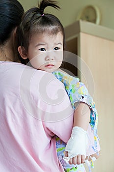 Illness child in hospital, saline intravenous (IV) on hand asian