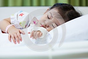 Illness child in hospital, saline intravenous (IV) on hand asian