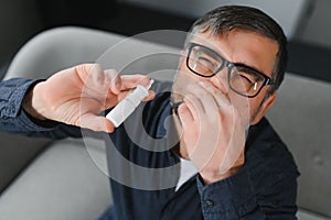 Illness And Sickness. Closeup Of man Feeling Sick Dripping Nasal Drops In Blocked Nose. Portrait male Sprays Cold And