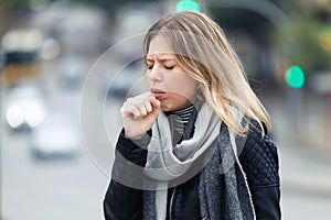 Illness young woman coughing in the street