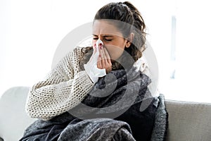 Illness young woman sneezing in a tissue.