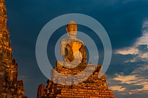 Illuminated ancient Buddha statue against cloudy sky on the back