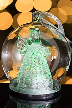 Illuminated angel figure in glass bulb, soft boke christmas ligh