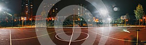 Illuminated basketball playground with red pavement, modern new basketball net