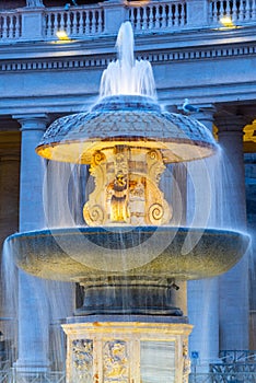 Illuminated Bernini Fountain at St Peters Basilica in the evening dusk. St Peters Square, Vatican