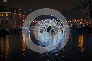 Illuminated bridge in Amsterdam at the Amstel in the Netherlands at night