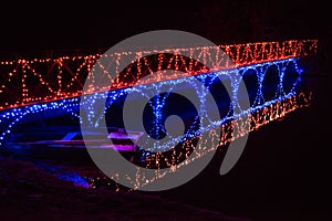 An illuminated bridge casts its light on a rowing boat