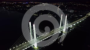 Illuminated bridge night cityscape industrial traffic transportation crossing river aerial view
