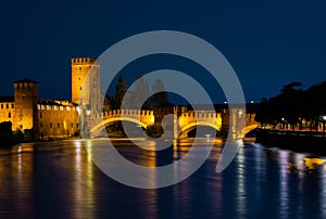 Illuminated bridge at night in Verona over the Adige River